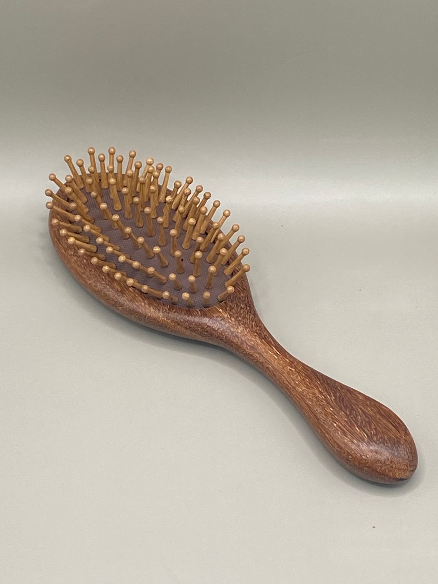 💆♀️ Démêle tes cheveux en douceur avec cette brosse en bois de santal, munie d’aiguilles en bambou et silicone. Confort, respect du cuir chevelu et style écolo au rendez-vous.