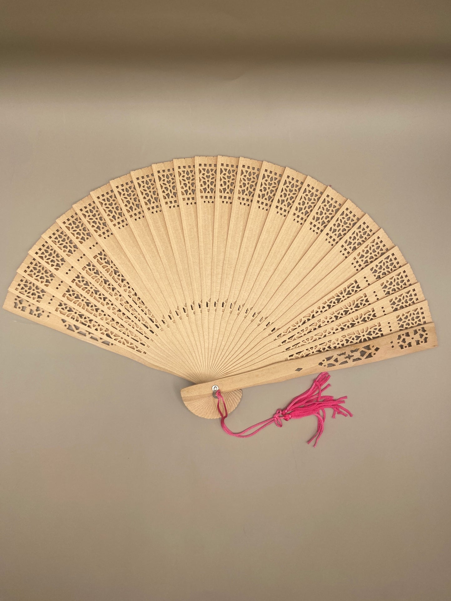 Un accessoire raffiné et utile pour se rafraîchir avec grâce. Cet éventail ajouré en bambou, orné d’un pompon décoratif, allie tradition, élégance et durabilité.