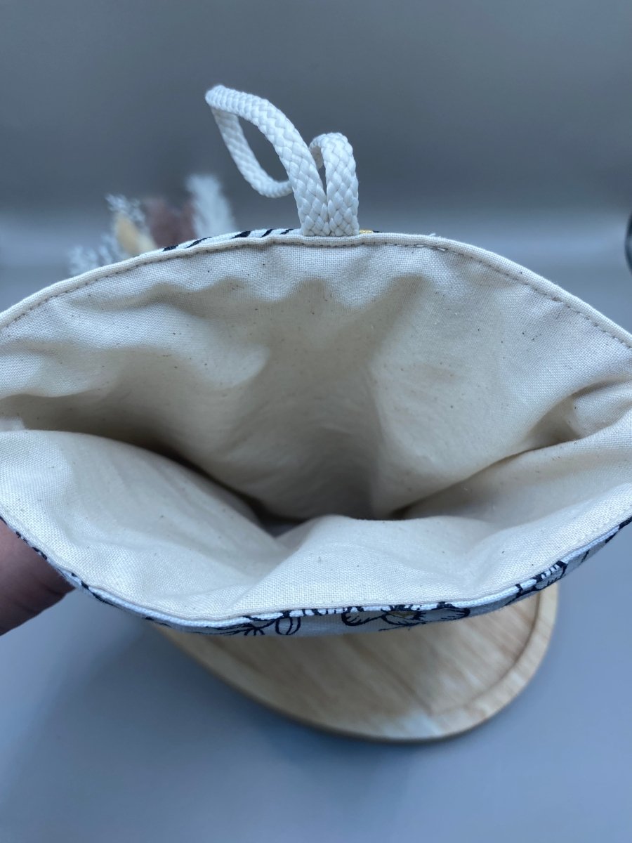 Gros plan sur la fermeture cordelette et bouton en bois de la housse livre artisanale Mon EcoKit