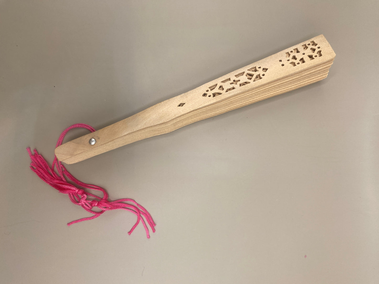 Un accessoire raffiné et utile pour se rafraîchir avec grâce. Cet éventail ajouré en bambou, orné d’un pompon décoratif, allie tradition, élégance et durabilité.