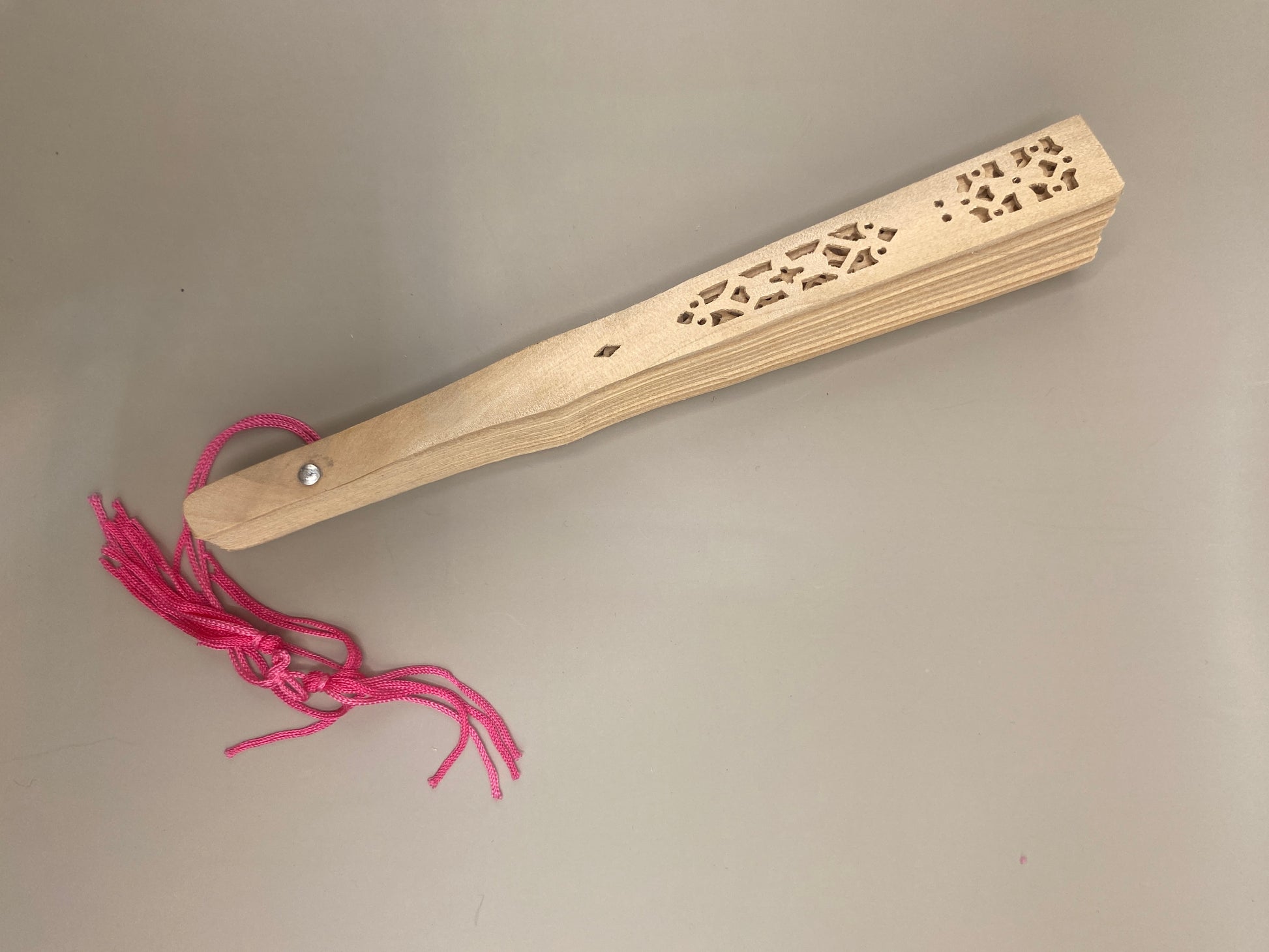 Un accessoire raffiné et utile pour se rafraîchir avec grâce. Cet éventail ajouré en bambou, orné d’un pompon décoratif, allie tradition, élégance et durabilité.