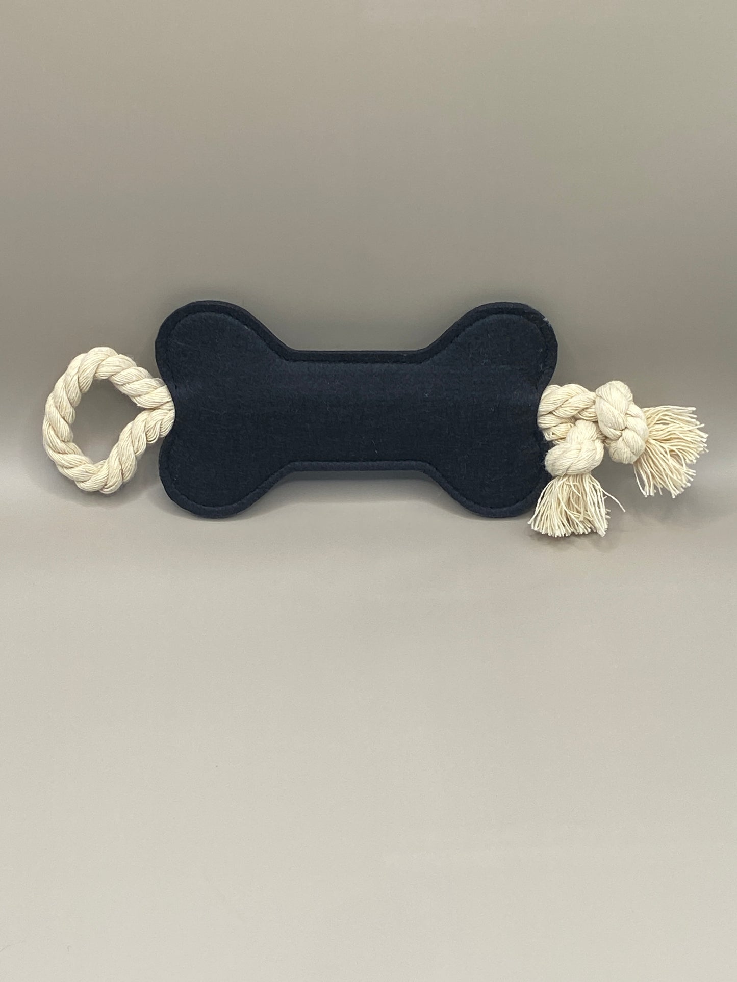 Offre à ton compagnon à quatre pattes un jouet sain et amusant ! Cet os en feutre noir avec corde intégrée est conçu pour résister aux jeux doux et au mordillage léger, tout en apportant un vrai moment de complicité.