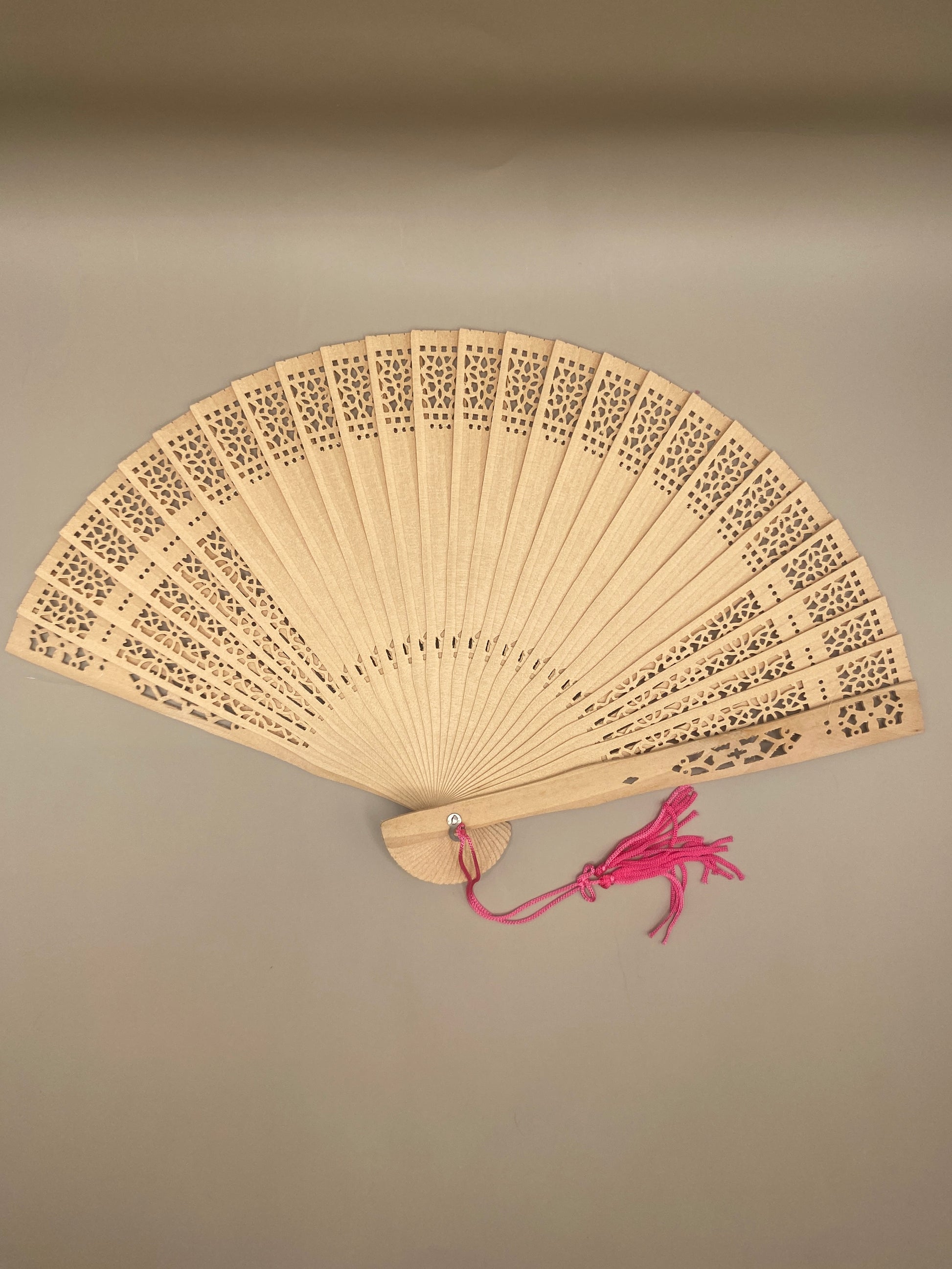Un accessoire raffiné et utile pour se rafraîchir avec grâce. Cet éventail ajouré en bambou, orné d’un pompon décoratif, allie tradition, élégance et durabilité.